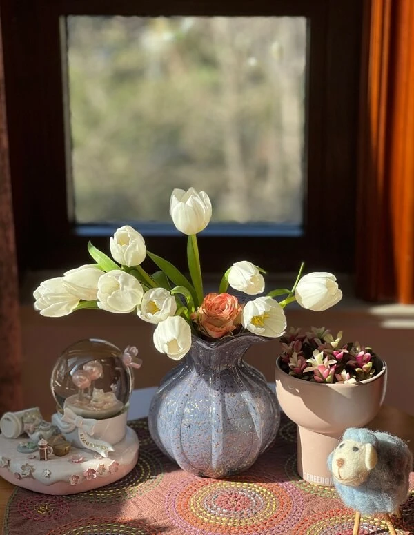 một cái bàn với một chiếc bình và hoa trên đó ảnh hoa tulip