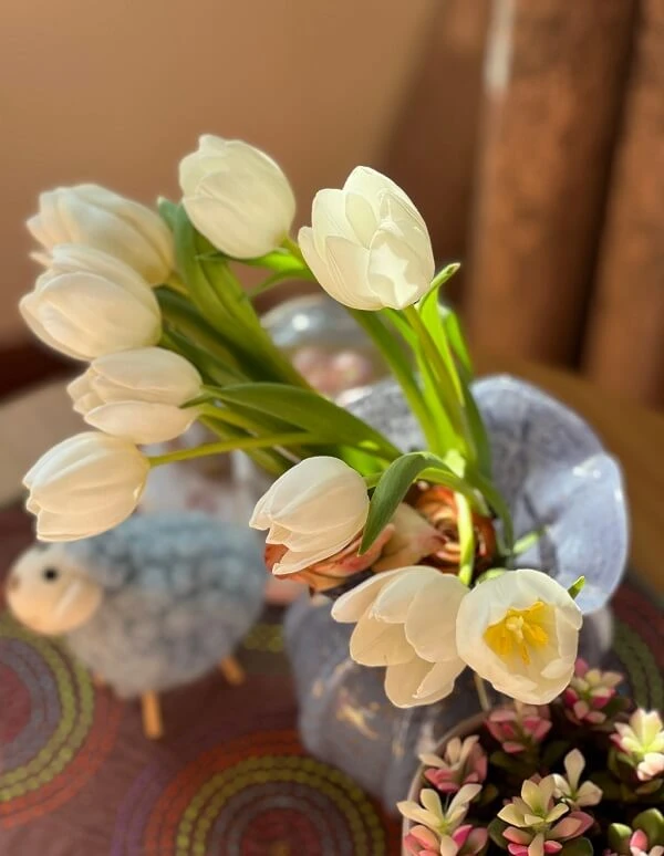 một chiếc bình có hoa trong đó trên bàn ảnh hoa tulip