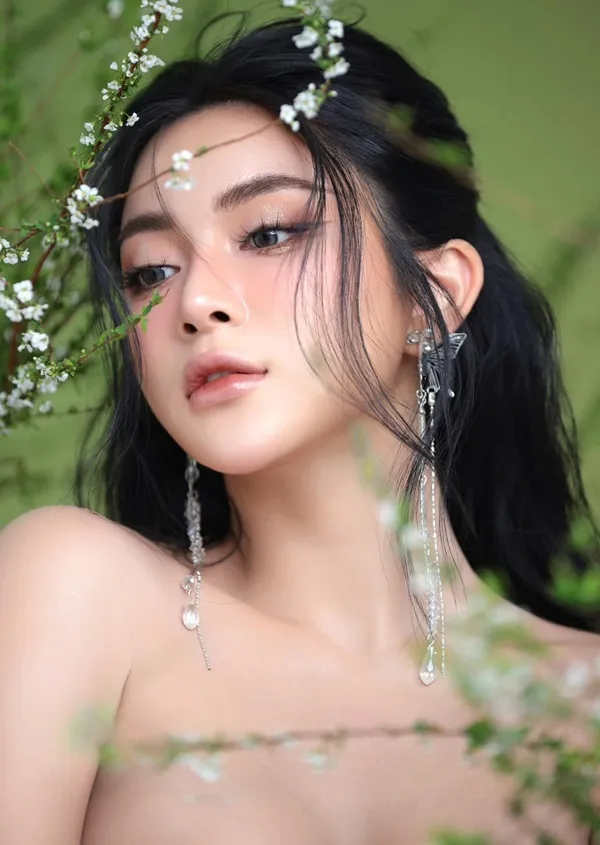 Có một người phụ nữ mái tóc đen dài tạo dáng cho bức tranh