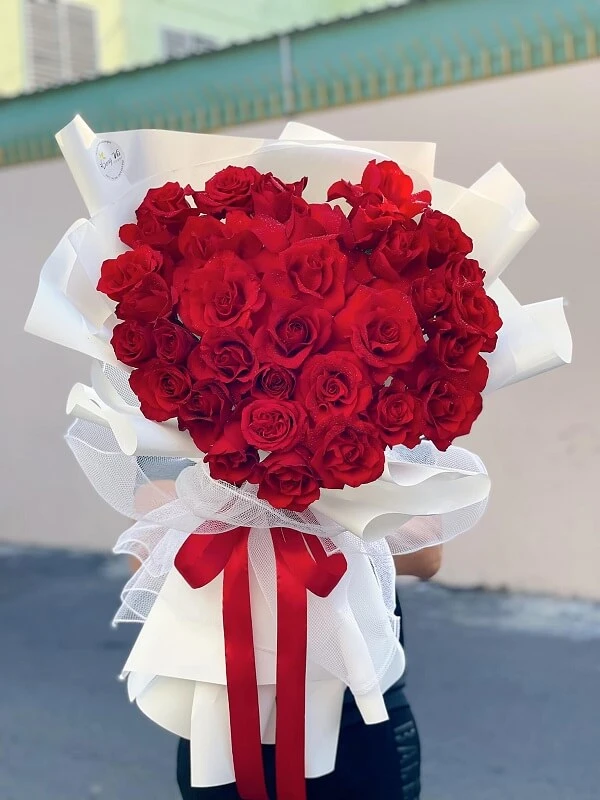 Một người phụ nữ cầm một bó hoa hồng đỏ ảnh hoa valentine