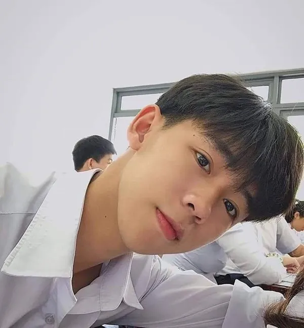 Ảnh trai đẹp học sinh có một chàng trẻ ngồi bàn làm việc trong lớp